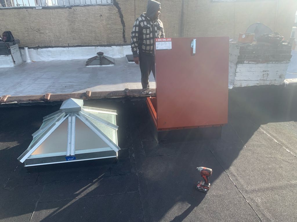 Skylight installation on flat roof with waterproofing