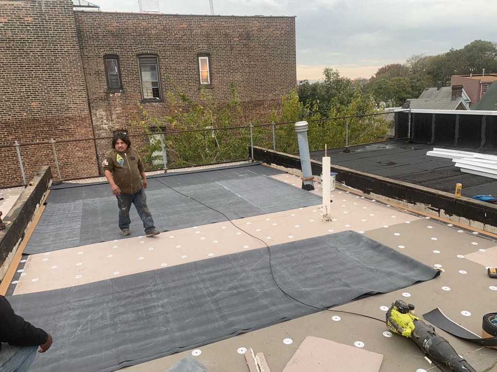 EPDM rubber roofing being laid on Brooklyn brownstone